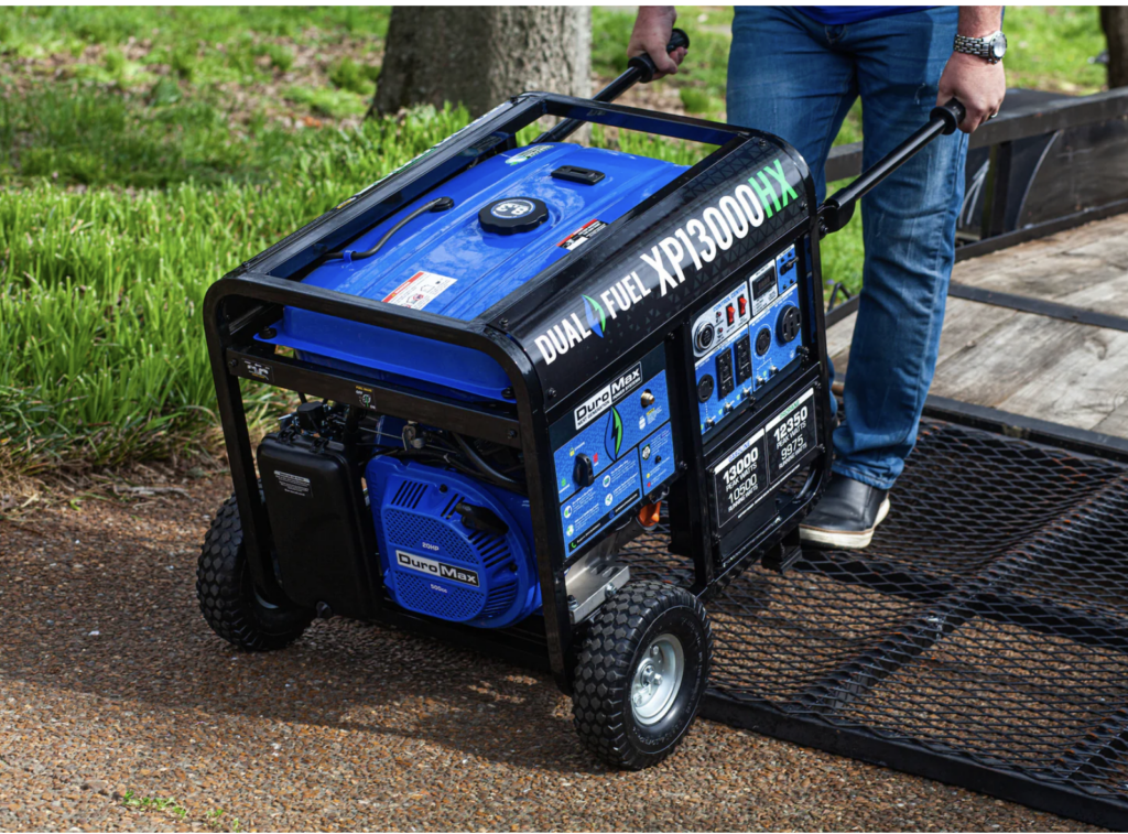Person moving a DuroMax portable generator into position
